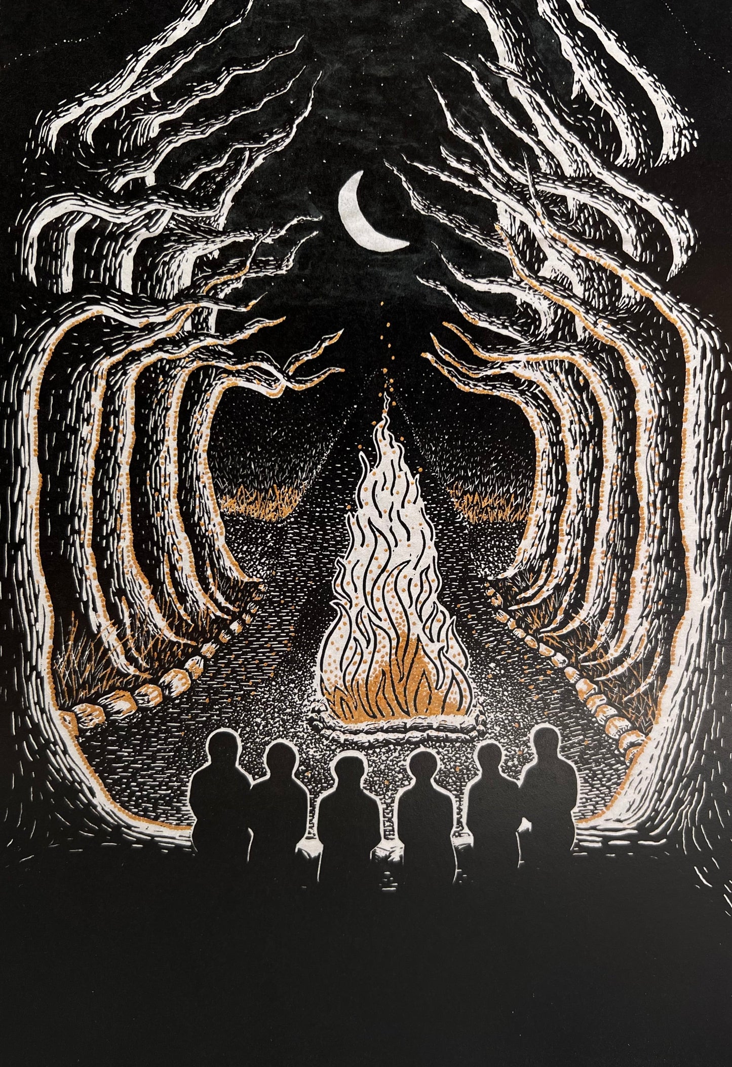 A black, white and gold greetings card featuring a campfire scene with silhouettes of 6 people facing a glowing fire, framed by gnarled, shadowy trees and a crescent moon in the sky.